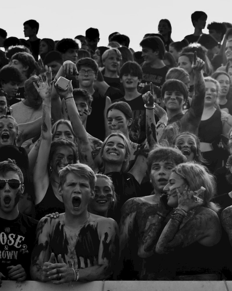 A packed student section cheering in the stands