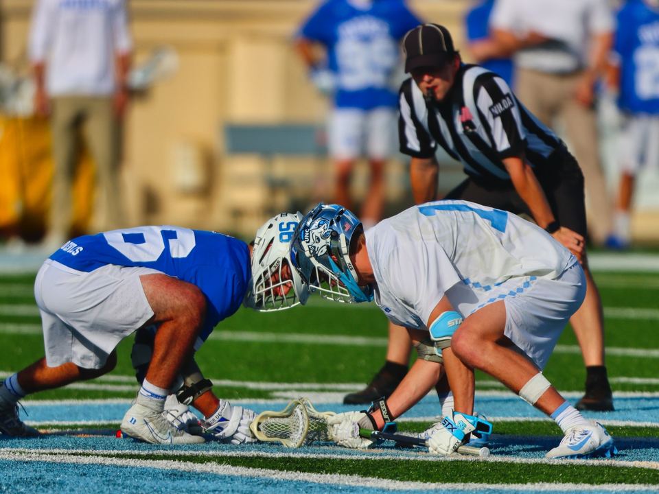 Two lacrosse players at the faceoff